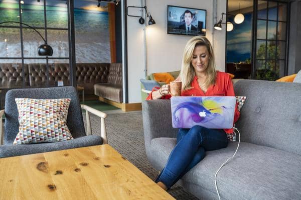 Airort Lounge with person enjoying a coffee on a sofa, using a laptop